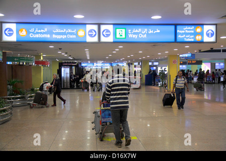 UAE di Dubai,Emirati Arabi Uniti,Aeroporto Internazionale di Dubai,gate,terminal,arrivo,viaggiatori,passeggeri motociclisti,cartello,frecce,indicazioni,b Foto Stock