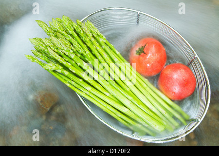 Asparagi verdi e i pomodori in un cestello Foto Stock