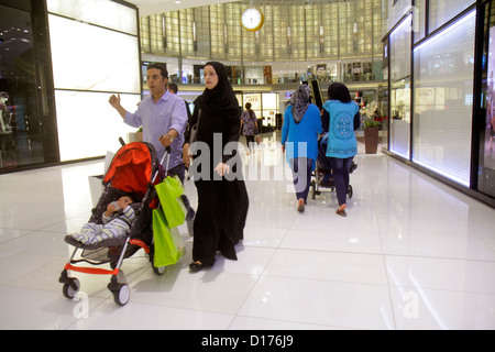 Dubai UAE,Emirati Arabi Uniti,Downtown Dubai,Burj Dubai,Dubai Mall,atrio,musulmano,donna femminile donne,scialle,accappatoio,hijab,madre,genitore,genitori,moglie,uomo m Foto Stock