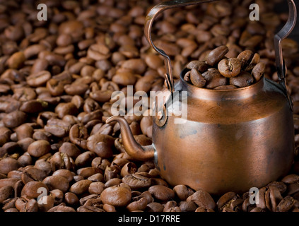 Caffettiera con luce il caffè torrefatto in grani, il fuoco selettivo Foto Stock