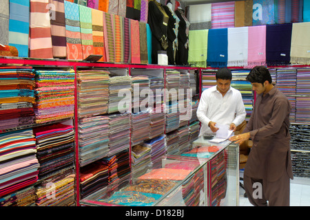 Dubai UAE,Emirati Arabi Uniti,al Souqe al Kabeer,Old Souq,mercato,mercante,musulmano,tessile,materiale di abbigliamento,seta,commerciante,commerciante,proprietario,impiega Foto Stock