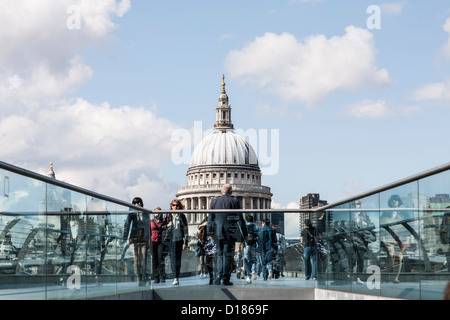 Gente correre intorno sul Millennium bridge con St Pauls in background Foto Stock