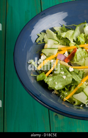 Insalata verde in blu ciotola sul tavolo di legno Foto Stock