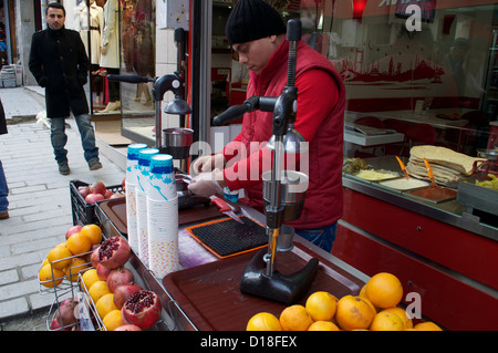 Il succo di melograno venditore in Istanbul Turchia premendo melograni freschi in un mercato Foto Stock