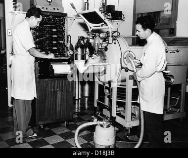 I medici stanno studiando il meccanismo della tosse in un paziente di polio in un polmone di ferro respiratore. Rancho Los Amigos respiratore Center, Foto Stock