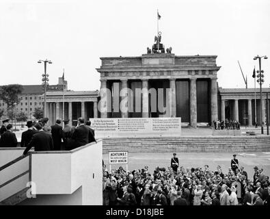 Il presidente John Kennedy visiti il muro di Berlino. Da una speciale piattaforma integrata presso la Porta di Brandeburgo, il presidente Kennedy sembra Foto Stock