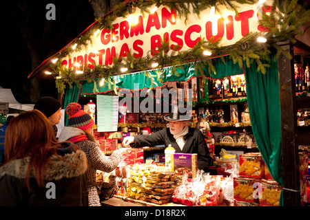 L annuale mercatino di Natale di Lincoln, Inghilterra, Regno Unito. Un biscotto tedesco venditore sul suo stallo. Foto Stock