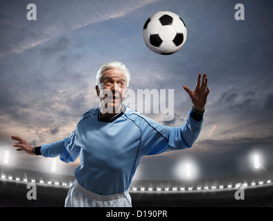 Senior uomo a giocare il gioco del calcio Foto Stock