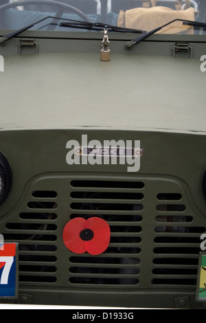 Un ricordo rosso papavero bloccati sulla parte anteriore di un classico jeep militari ad un auto show. Foto Stock