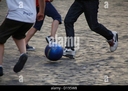 I bambini che giocano a calcio in strada di roma italia Foto Stock