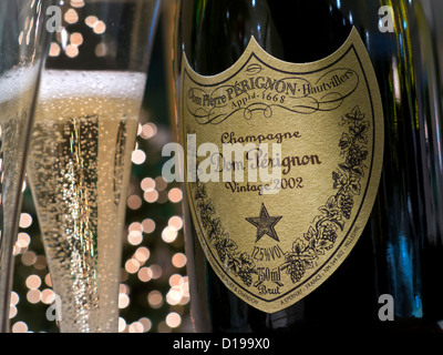 Appena spillata bicchieri di annata 2002 Dom Perignon champagne di lusso con luci scintillanti in background Foto Stock