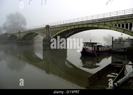 Barche ormeggiate sul fiume Tamigi, vicino a Richmond bridge rampa, visto su un nebbioso giorno in inverno Foto Stock