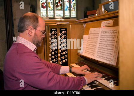 Chiesa organista giocando alla chiesa di San Lorenzo, Alton, HAMPSHIRE, Regno Unito. Foto Stock