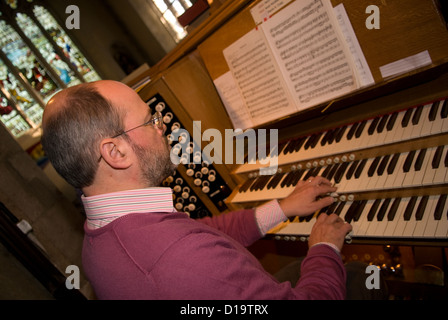 Chiesa organista giocando alla chiesa di San Lorenzo, Alton, HAMPSHIRE, Regno Unito. Foto Stock