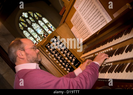 Chiesa organista giocando alla chiesa di San Lorenzo, Alton, HAMPSHIRE, Regno Unito. Foto Stock