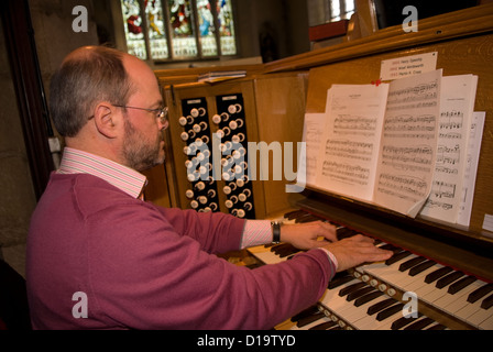 Chiesa organista giocando alla chiesa di San Lorenzo, Alton, HAMPSHIRE, Regno Unito. Foto Stock