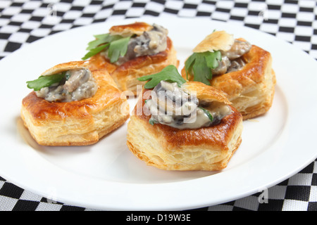 Una piastra di testa a fungo casalinga vol-au-vent guarnito con una foglia di prezzemolo Foto Stock