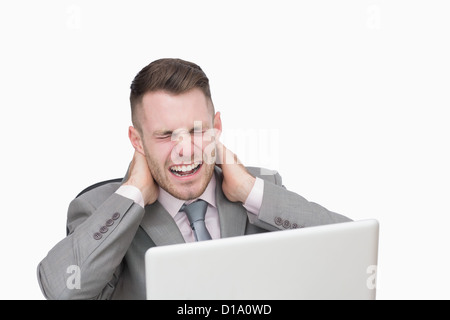 Uomo d'affari affetti da gravi dolori al collo durante l'utilizzo di laptop Foto Stock