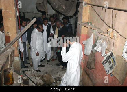 Bomb Squad di smaltimento (BDS) funzionari ispezione sito per raccogliere prove dopo la bomba in un negozio di tè, in zona Landhi a Karachi il Mercoledì, 12 dicembre 2012. Due persone uccise tra cui un ufficiale di polizia secondo l'eliminazione della bomba Squad (BDS) bomba è stata il controllo remoto e collocata all'interno della tabella. Foto Stock