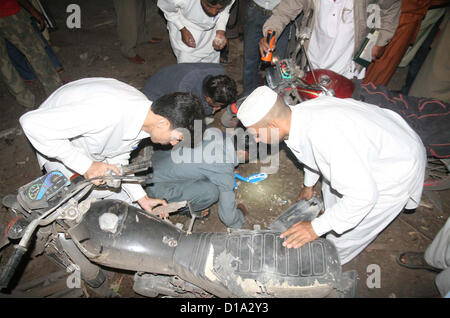 Bomb Squad di smaltimento (BDS) funzionari ispezione sito per raccogliere prove dopo la bomba in un negozio di tè, in zona Landhi a Karachi il Mercoledì, 12 dicembre 2012. Due persone uccise tra cui un ufficiale di polizia secondo l'eliminazione della bomba Squad (BDS) bomba è stata il controllo remoto e collocata all'interno della tabella. Foto Stock