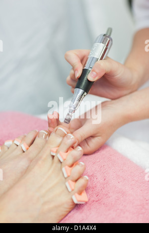 Le mani la rimozione di callo osseo in corrispondenza dei piedi Foto Stock