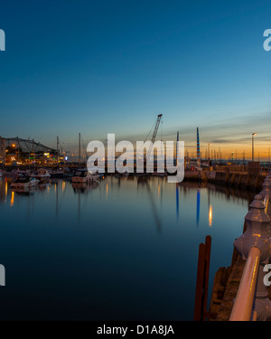 Torquay, Devon, Inghilterra. Il 10 dicembre 2012. Torquay porto interno al tramonto con riflessi del Cill Bridge. Foto Stock