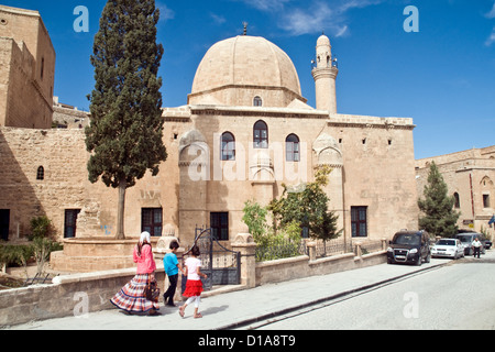 Una madre e i suoi figli camminano in una vecchia moschea di pietra del XV secolo nella città di Mardin, nella regione orientale dell'Anatolia, nella Turchia sudorientale. Foto Stock