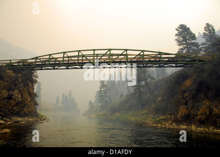 Il sentiero ponte sopra la forcella centrale del fiume di salmoni con forest incendio fumo in aria, Idaho. Foto Stock