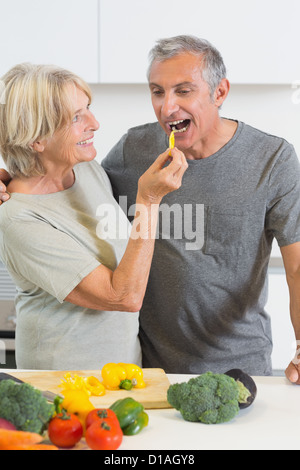 Il marito assaggiando una fetta di peperone giallo Foto Stock