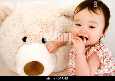 Sweet Baby girl con gigantesco orso di peluche Foto Stock