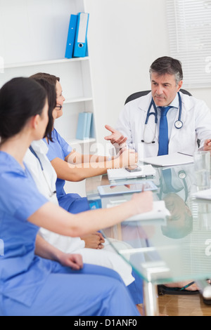 Incontro tra un medico e tre infermieri Foto Stock