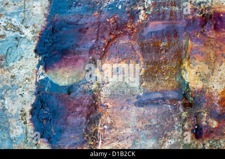 Il vecchio muro di cemento con forte rosso-marrone a macchie di ruggine e calcestruzzo. Foto Stock