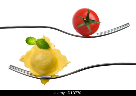 Ravioli e pomodoro ciliegino su una forcella con basilico guarnire contro uno sfondo bianco. cibo tradizionale italiano concept Foto Stock