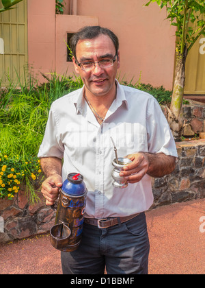 Un maschio paraguaiane, insegnante di scuola media si prende una pausa e tiene una tazza di tereré con il metallo della paglia. Foto Stock