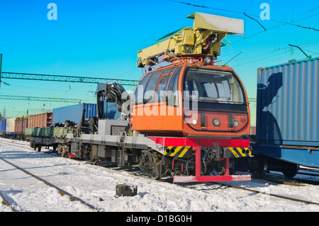 Treno carrello gru. Gru idraulica montata su un vagone ferroviario (treno merci) per il sollevamento del legname. Offerte carro ferroviario. Foto Stock