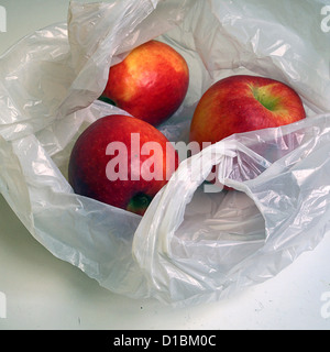 Tre mele rosse in un sacchetto di plastica. Foto Stock