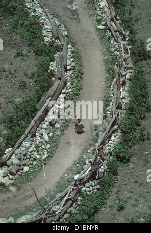 La questione del Kashmir, Sind Valley, guardando in giù su un bambino piccolo che corre lungo un percorso di villaggio tra ruvidi muri in pietra a secco Foto Stock