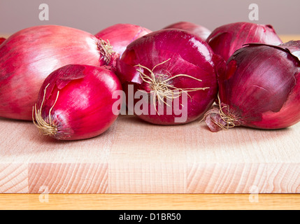 Le cipolle rosse sul legno nero di trinciatura Foto Stock