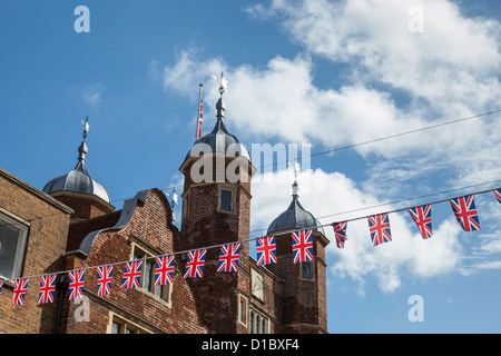 Stringa di flag di Unione contro un cielo blu con Abbot's Hospital dietro, Guildford, Inghilterra. Foto Stock