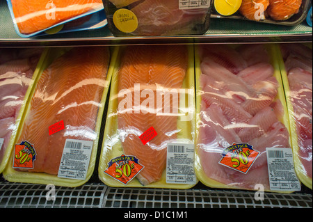 Pacchetti di salmone e tilapia in un supermercato in New York quartiere di Chelsea Foto Stock