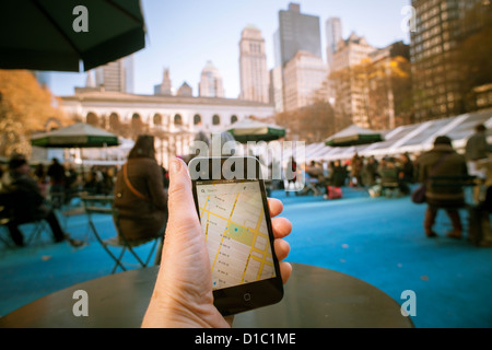 Un utente iPod touch consente di visualizzare le mappe di Google app sul suo dispositivo in Bryant Park di New York Foto Stock