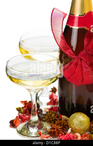 Dettaglio della bottiglia di champagne con rosso di prua di Natale, due bicchieri pieni e la decorazione su sfondo bianco. Foto Stock