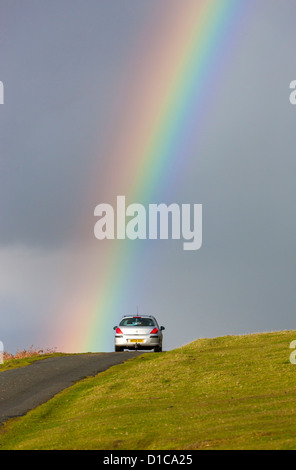 Rainbow su strada vicino a Cox Tor nel Parco Nazionale di Dartmoor, Devon, Inghilterra, Regno Unito, Europa Foto Stock