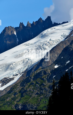 E frastagliate cime delle montagne circondano questo grande coperta di neve glacier Foto Stock