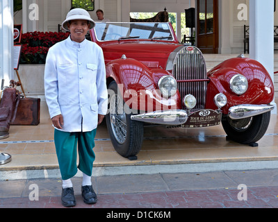 Portantino presso un hotel di Tailandia e un rosso Bugatti 1938 modello tipo 57 veterano autovettura. Thailandia SUDEST ASIATICO Foto Stock