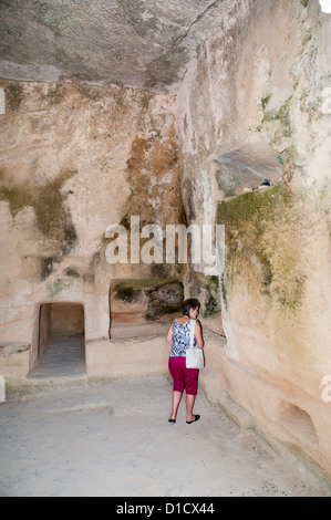 Tourist all'interno di una delle molte tombe presso le tombe dei re sito in Paphos Cipro Foto Stock