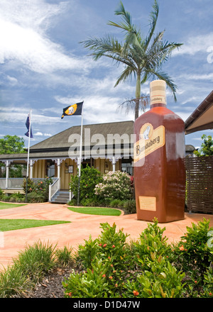 Gigantesca bottiglia di rum e storico cottage in ingresso alla distilleria Bundaberg Rum Foto Stock