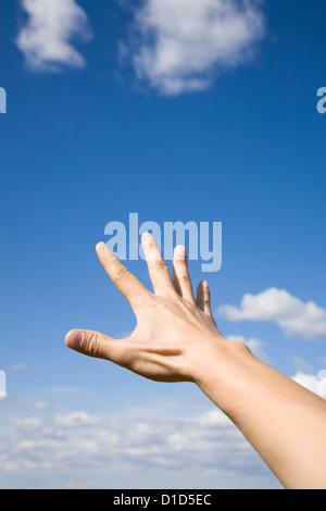 Mano d'uomo fino a raggiungere il blu del cielo. Foto Stock