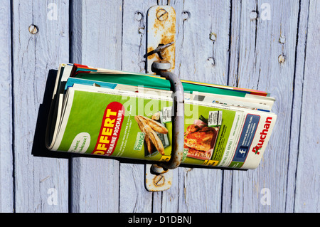 La posta indesiderata a sinistra in la maniglia di una porta in un villaggio francese. Foto Stock