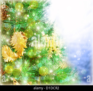 Immagine dell albero di Natale di frontiera, verde di pini albero decorato con fiocchi di neve dorata isolati su blue blur sullo sfondo Foto Stock